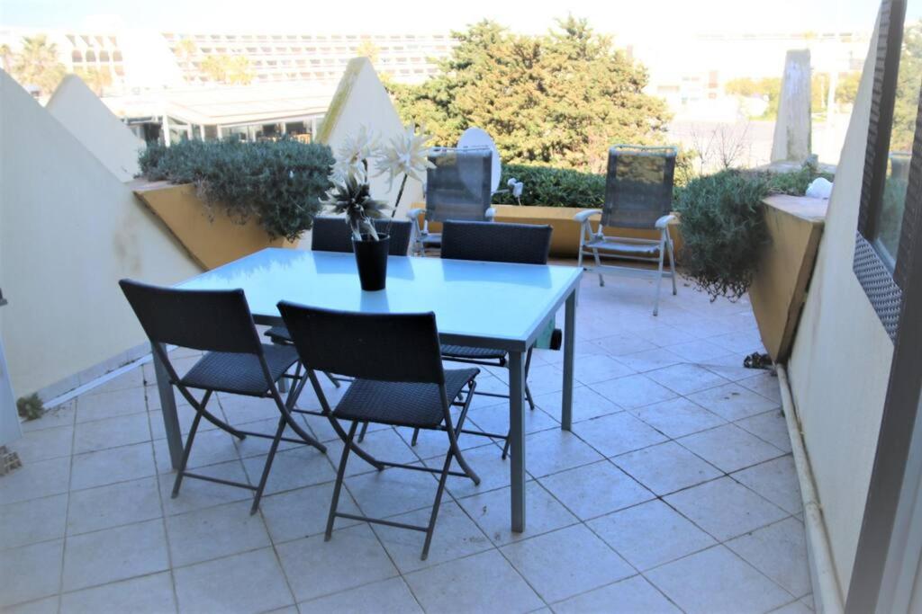 une table et des chaises bleues sur une terrasse dans l'établissement Studio 659, Port Nature 6 au village naturiste, au Cap d'Agde