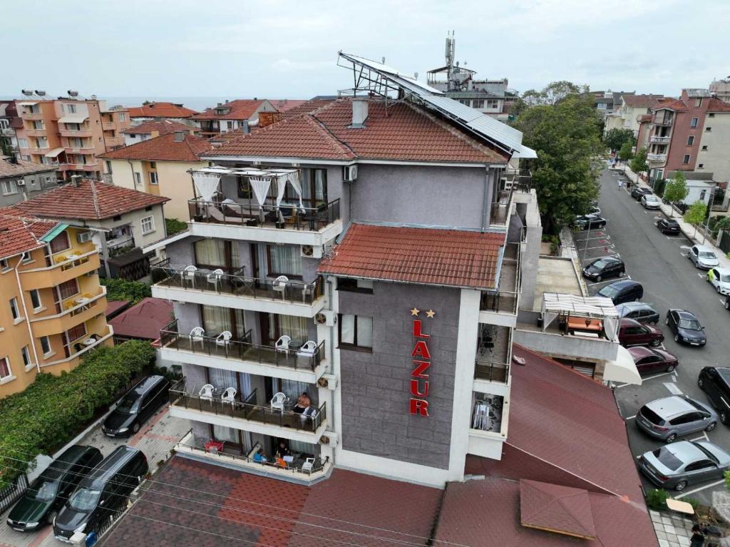 a building with a red sign on the side of it at Hotel Lazur in Kiten