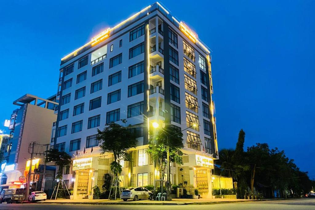 um edifício branco alto com luzes em cima em Kampot Sunny Hotel em Kampot