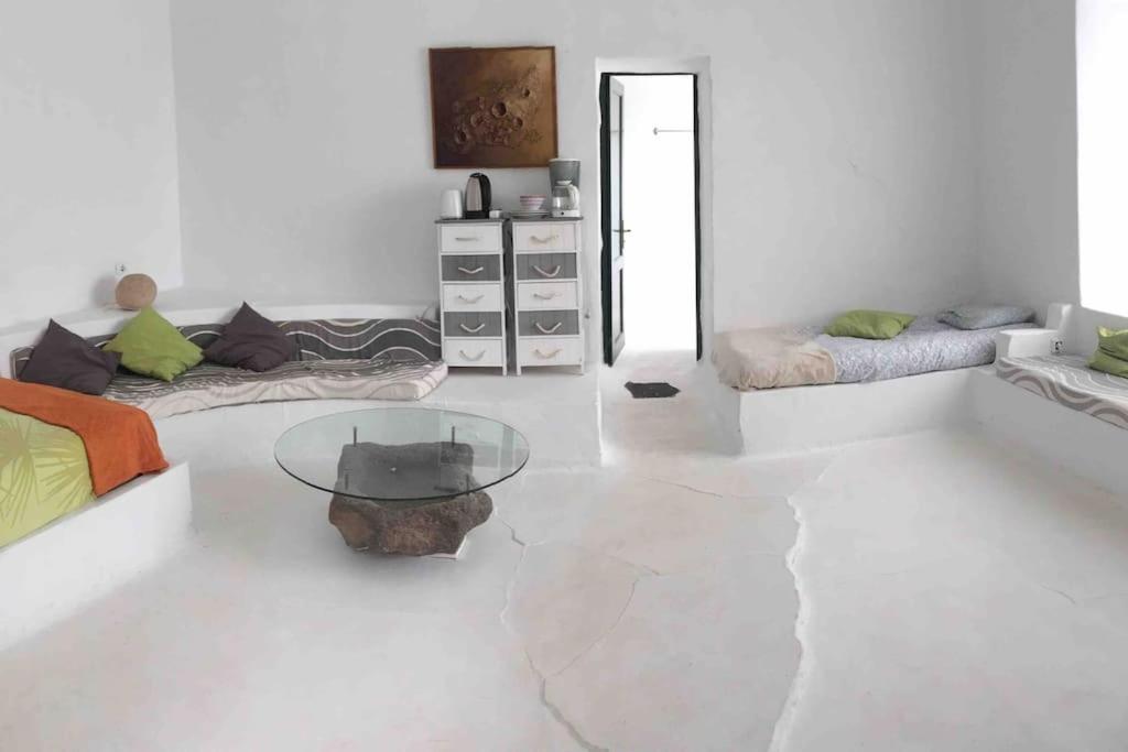 uma sala de estar branca com uma mesa de vidro em Studio III at orig. Finca,, sea views em La Asomada