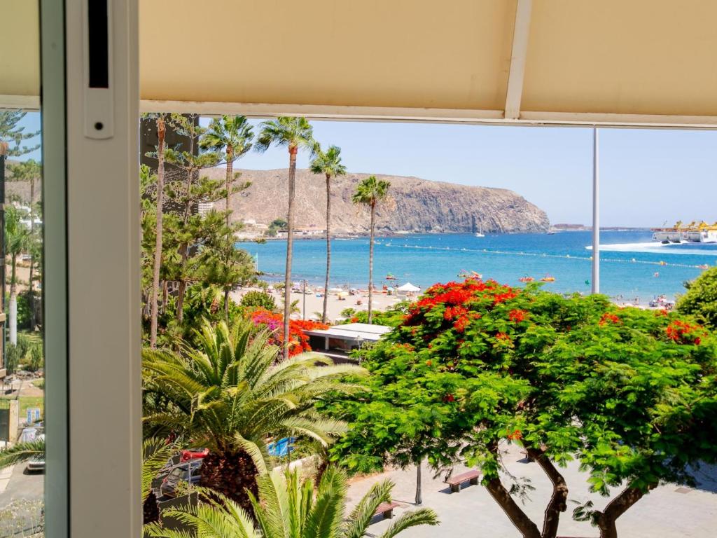 ein Fenster mit Blick auf den Strand von einem Resort in der Unterkunft Casa Peter Los Cristianos in Los Cristianos