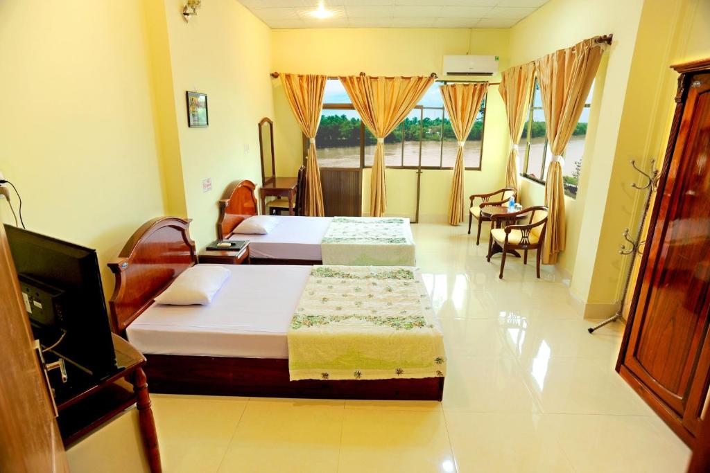 a hotel room with two beds and a television at Hung Vuong Hotel in Ben Tre