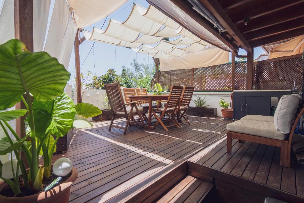 une terrasse en bois avec une table et des chaises. dans l'établissement The new Gurami Beach House, à Rincón de la Victoria