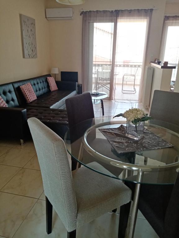 a living room with a glass table and chairs at Alasrooms Γ1 in Missolonghi