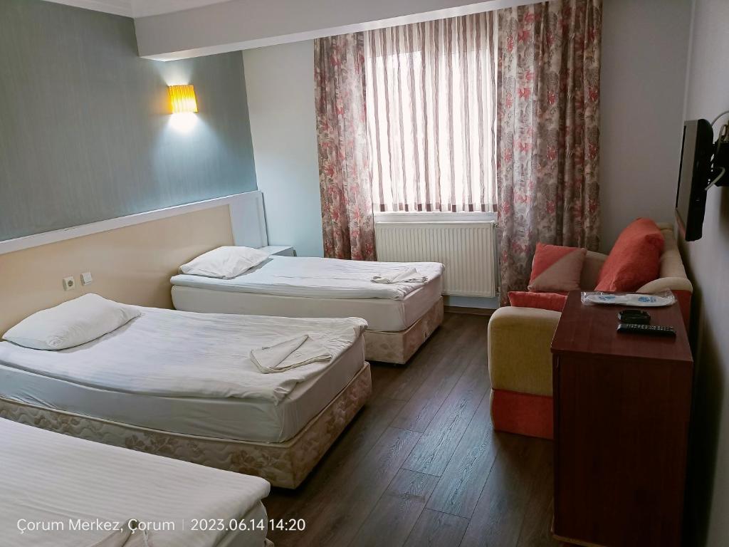 a hotel room with two beds and a couch at Şirin Apart in Corum