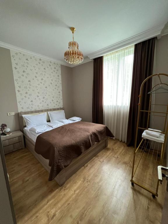 1 dormitorio con cama y lámpara de araña en Mountain KAZBEGI Apartment, en Kazbegi