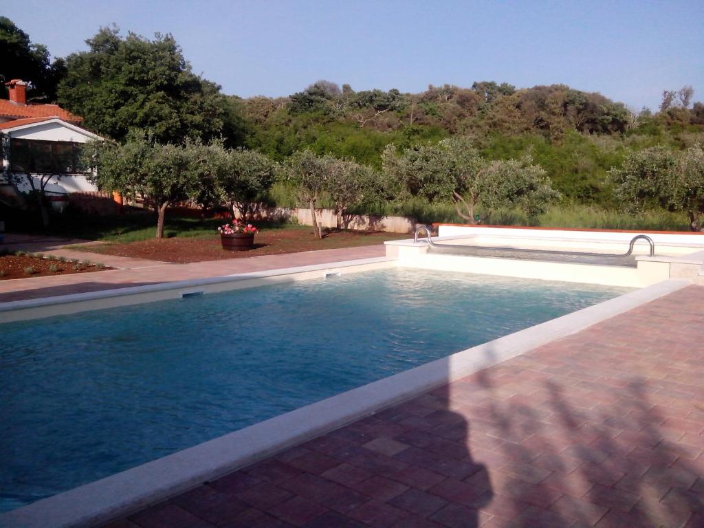 a swimming pool in a yard with trees at Jurman Apartment in Barbariga