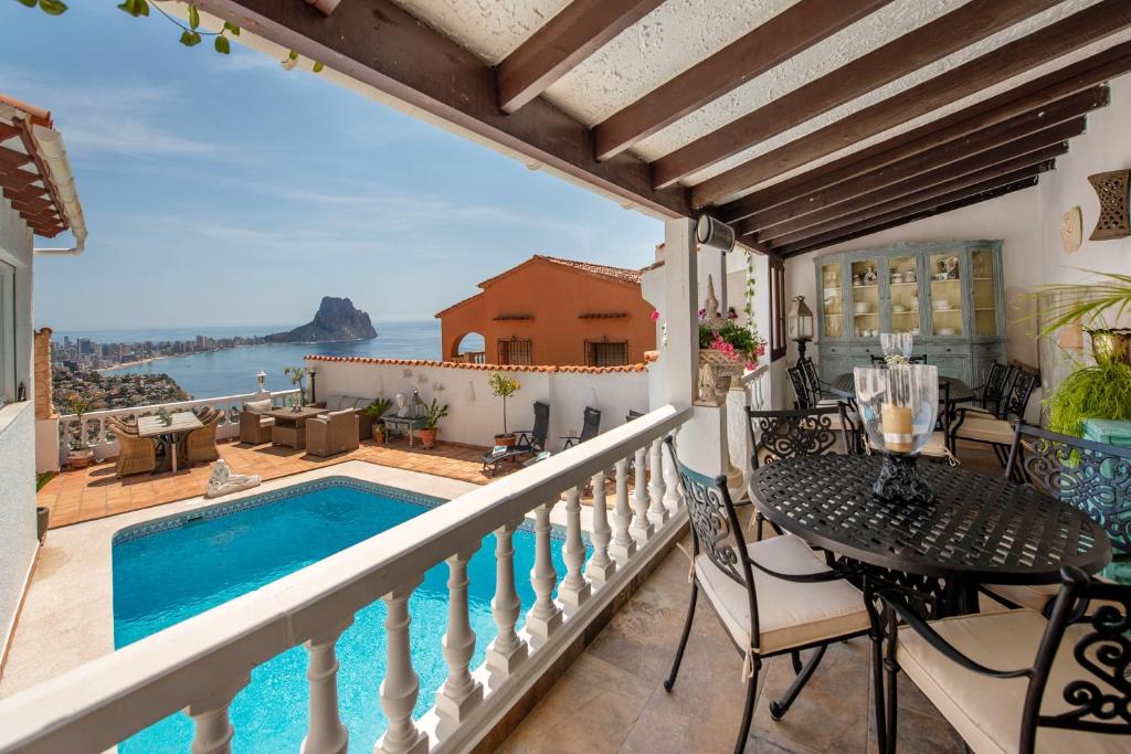 a balcony with a table and a swimming pool at Villa Vista Calpe in Calpe