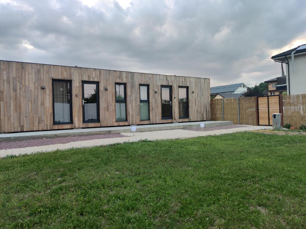 a building with windows on the side of a yard at Daro tiny house in Vama Veche