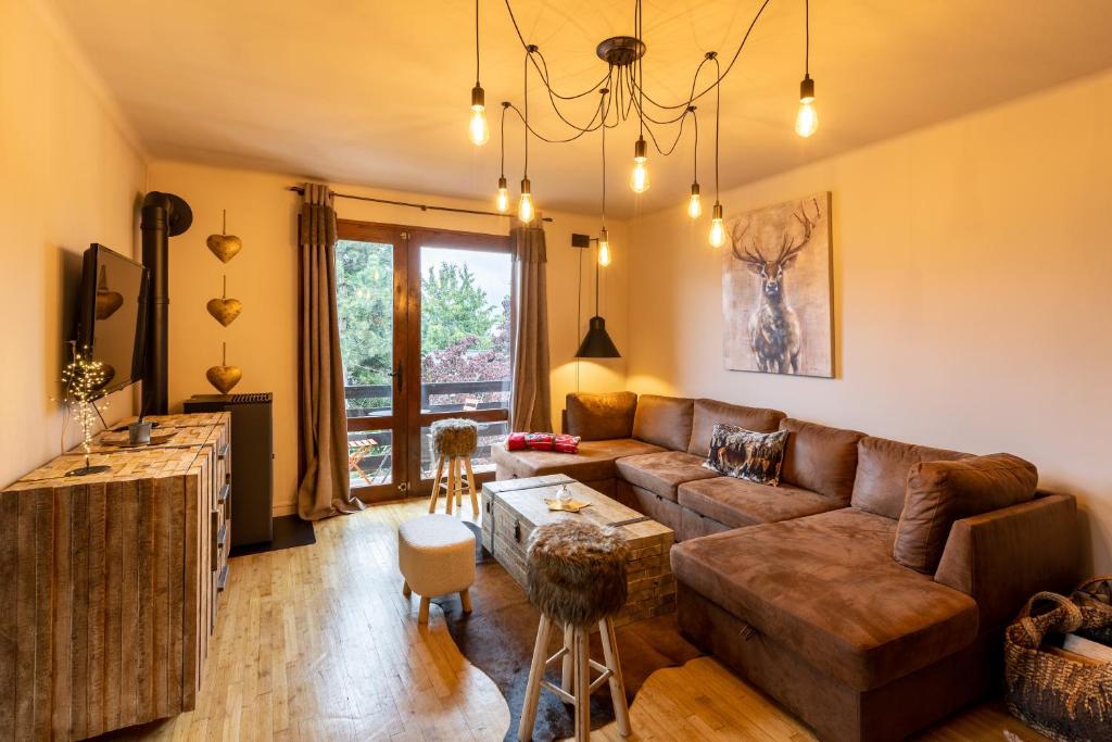ein Wohnzimmer mit einem Sofa und einem Tisch in der Unterkunft La Rose de Lou - Grand duplex avec vue montagne in Bolquere
