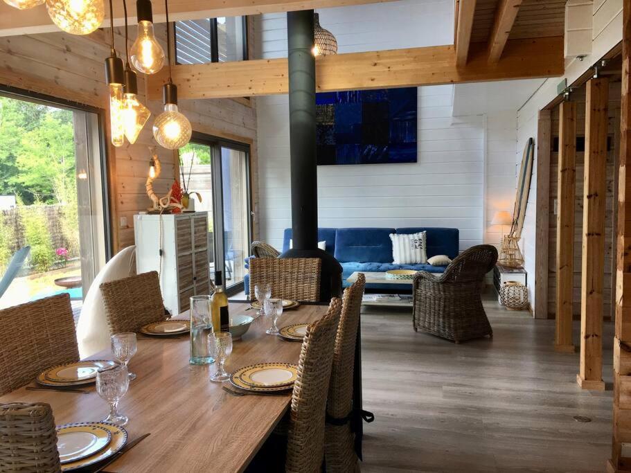 Un comedor con mesa y sillas de madera. en Superbe maison finlandaise en bois, en Tosse