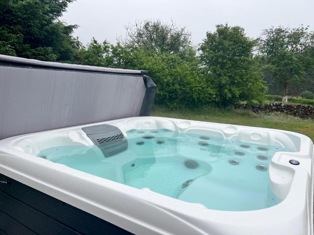 a jacuzzi tub sitting on top of a yard at Maberry Cottage in Bargrennan