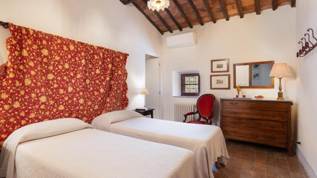 une chambre avec deux lits, une commode et un miroir dans l'établissement Crognole 6, Emma Villas, à Radda in Chianti