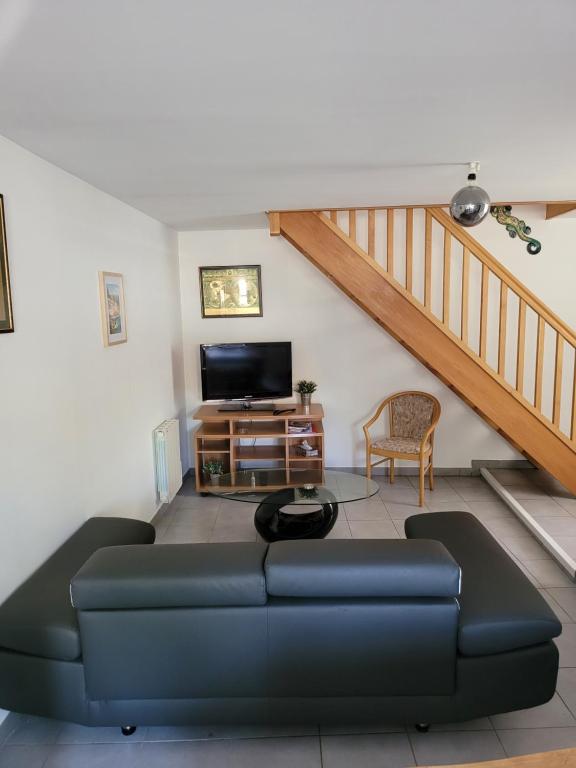 - un salon avec un canapé et une télévision dans l'établissement Appartement meublé Duplex T3., à Baume-les-Dames