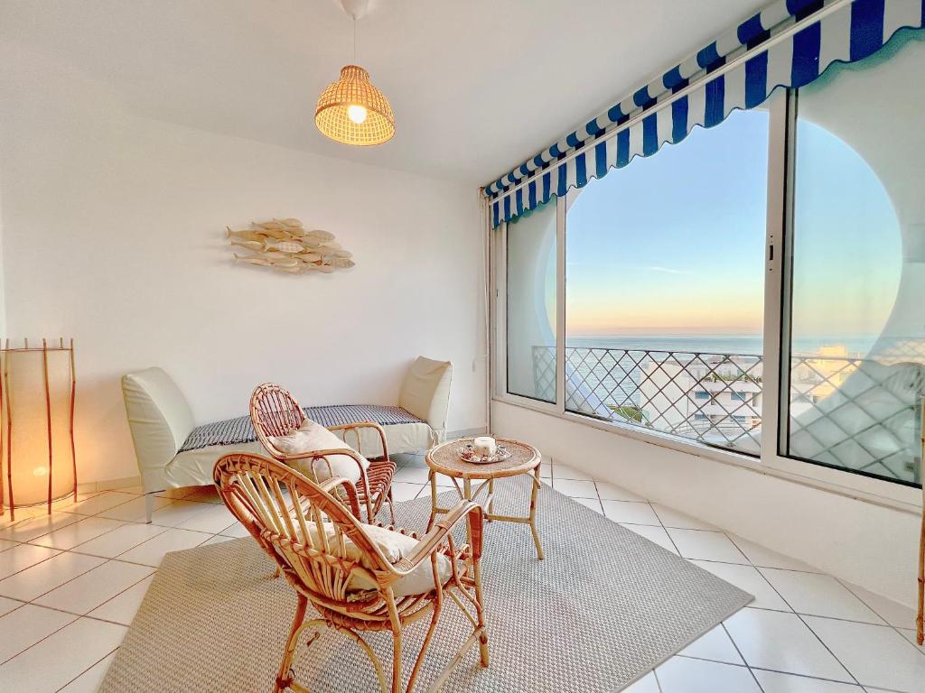 ein Wohnzimmer mit einem Tisch und Stühlen sowie einem großen Fenster in der Unterkunft Re del MARE - [Lounge con vista da SOGNO] in Porto Recanati