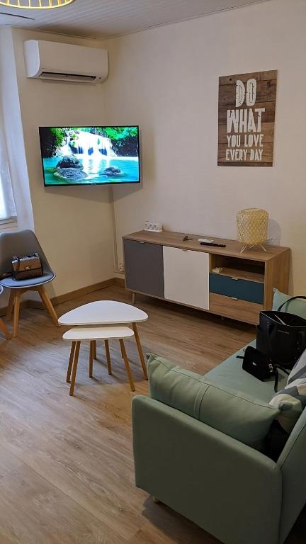 un salon avec un canapé et une télévision sur un mur dans l'établissement T1 Bis plein centre de Toulon,climatisé, à Toulon