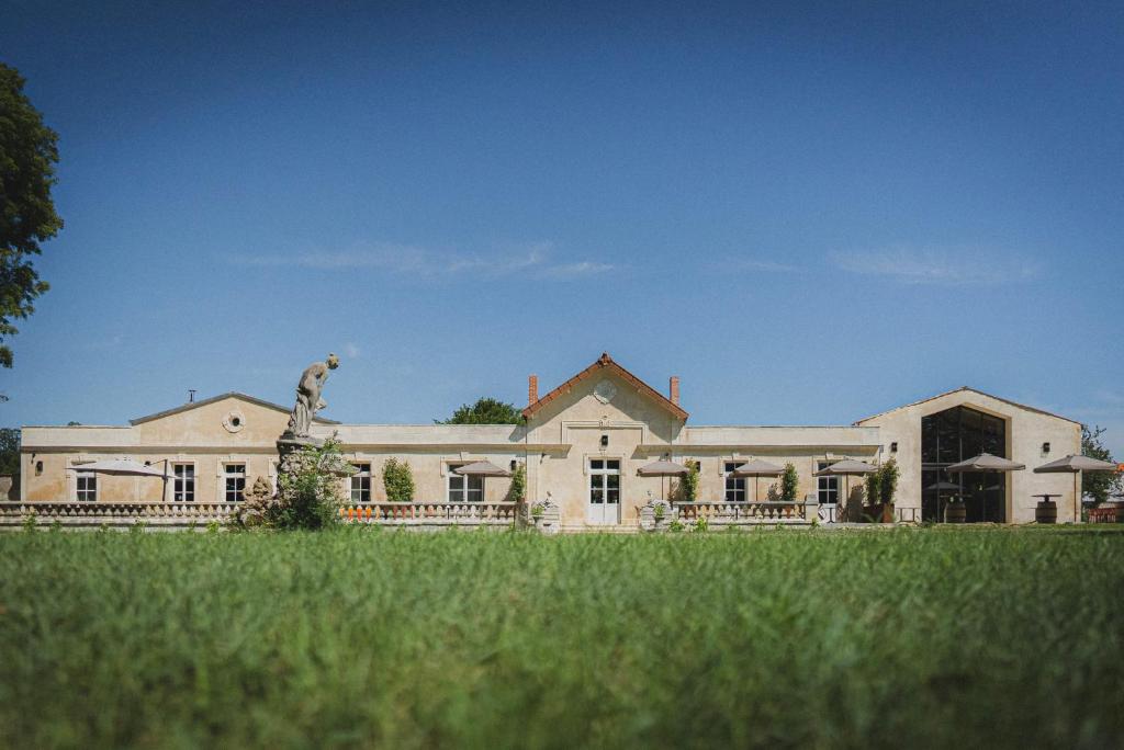 una casa grande con una estatua delante de ella en Logis de l'Héronière, en Salles-sur-Mer