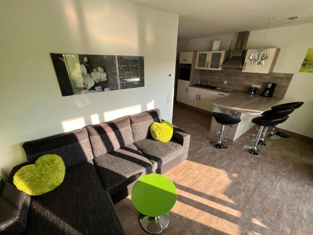 ein Wohnzimmer mit einem Sofa und einer Küche in der Unterkunft Ferienwohnung KWi 73 EG "grüne Oase" in Graal-Müritz