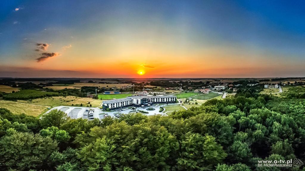 an aerial view of a building with the sunset in the background at Hotel Mistral Sport in Gniewino