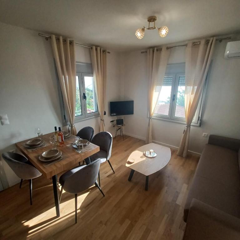 a living room with a table and chairs and a couch at Ionian Avra Apartment in Athani