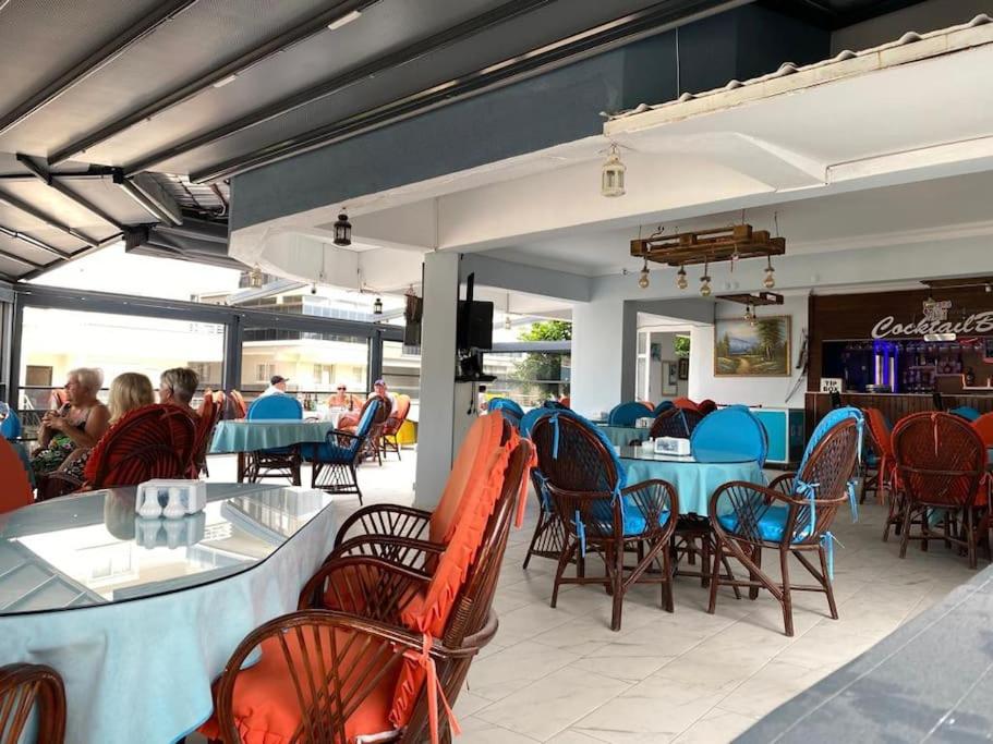 a dining room with blue tables and chairs and people at Apart Daire in Didim