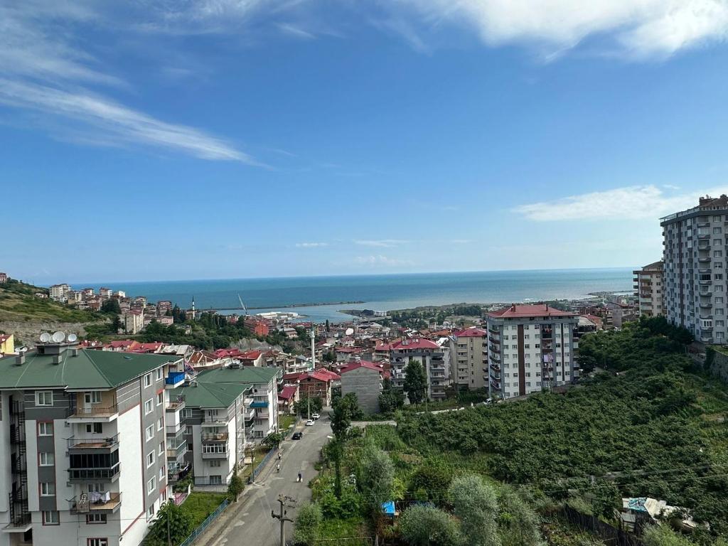 a city with buildings and the ocean in the background at VIP DAİRE DENİZ MANZARALI in Degirmen