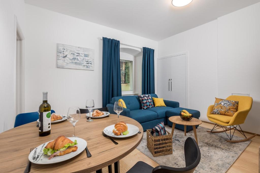 - un salon avec une table et un canapé bleu dans l'établissement El Caminante Apartment, à Rijeka