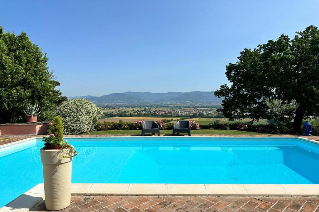 una piscina azul con 2 sillas y árboles en Villa Bucatino by Mmega, en Pistrino