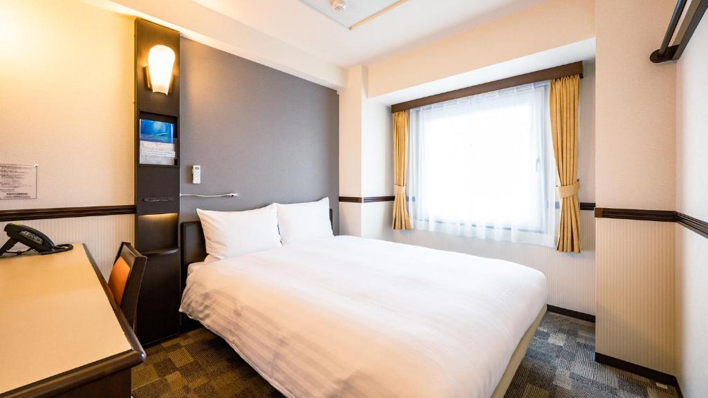 Postel nebo postele na pokoji v ubytování Toyoko Inn Hikone eki Higashi guchi