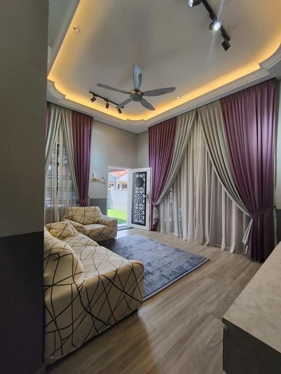a bedroom with two beds and a ceiling fan at Homestay 4BR with Outdoor Pool in Pasir Gudang