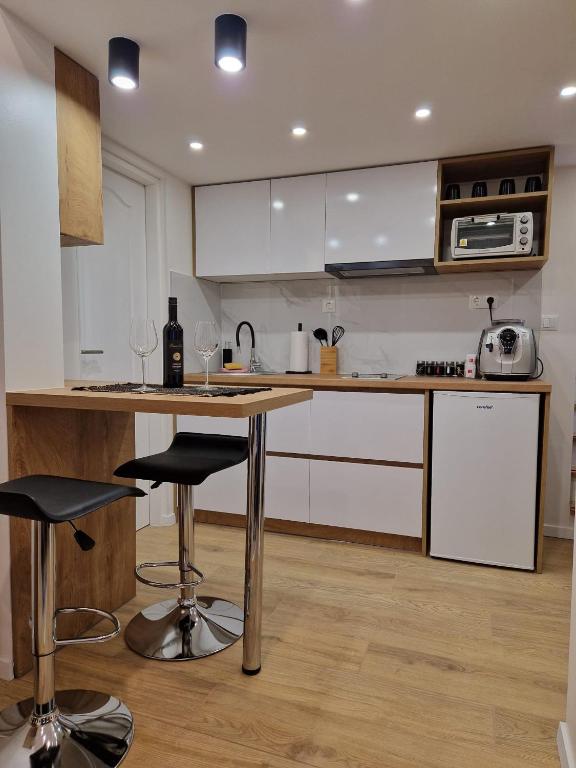 a kitchen with a counter and two bar stools at Apartman Gallery in Slavonski Brod