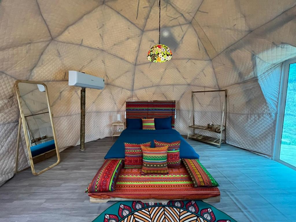 a bedroom in a yurt with a bed and pillows at Moon Muong Sang House 