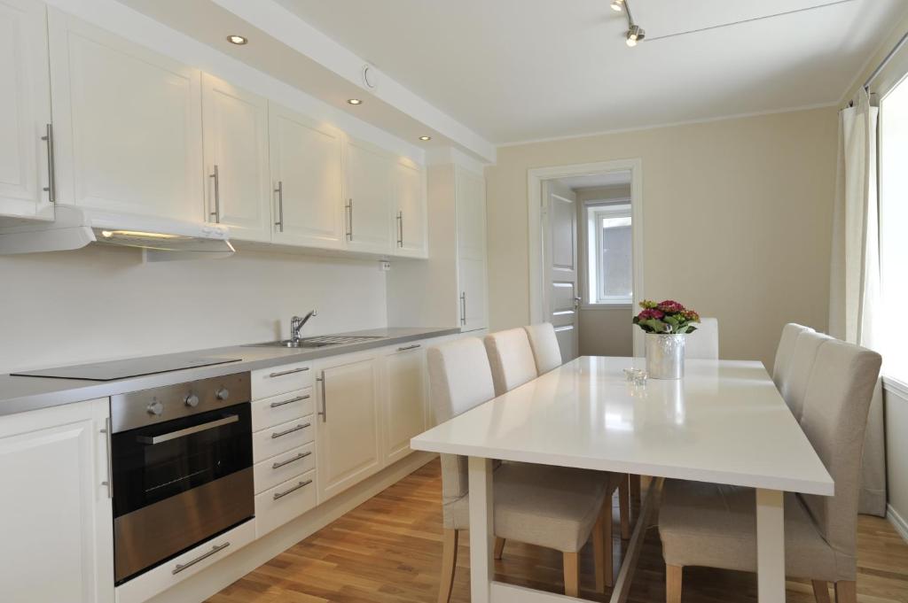 een witte keuken met een witte tafel en stoelen bij Geilo Gaarden in Geilo