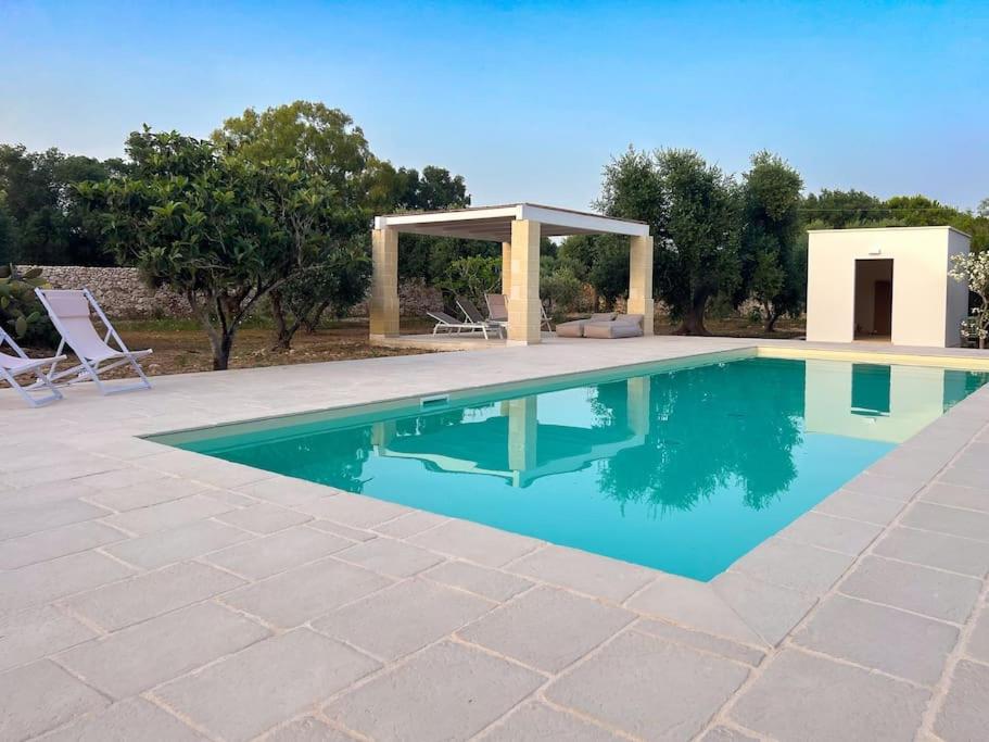 a swimming pool with a gazebo next to at Villaria Luxury apulian villa with pool in Campomarino