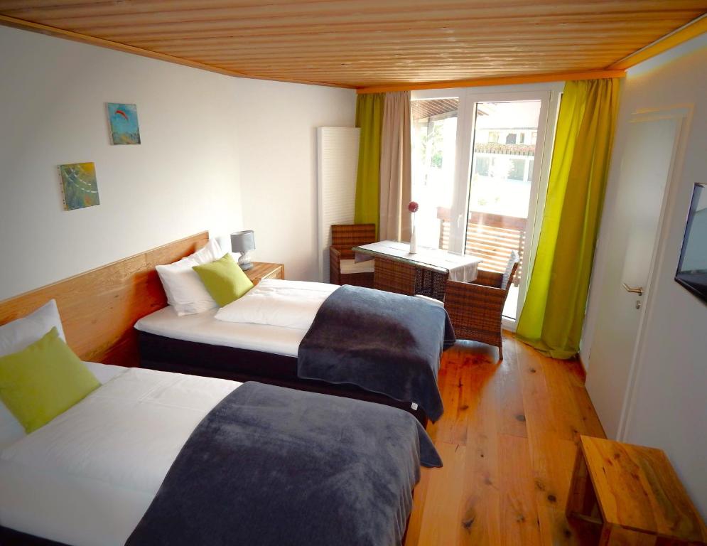 una camera d'albergo con due letti e una finestra di Vital Lodge Allgäu mit Oberstaufen PLUS a Oberstaufen