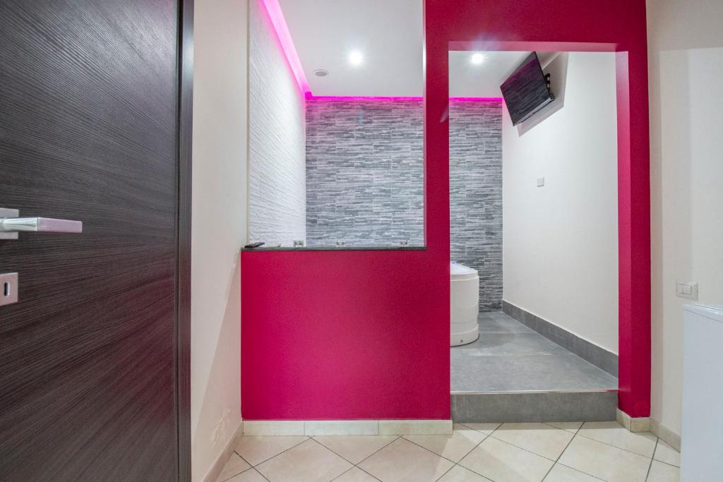 a bathroom with a red door and a toilet at Royal Playa Suite and Apartament -private parking- self chek out in Catania