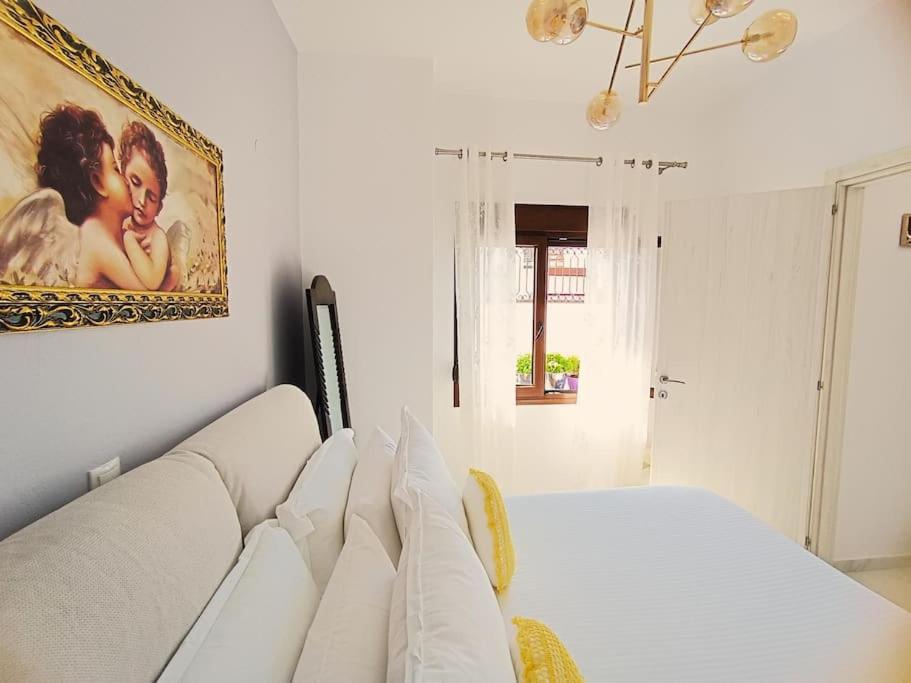 Inna Suite luxury apartment in the center في مدينة سكياثوس: أريكة بيضاء في غرفة مع صورة على الحائط
