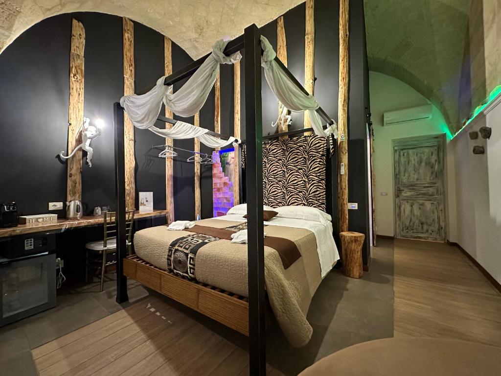 ein Schlafzimmer mit einem Himmelbett und einem Schreibtisch in der Unterkunft The Bridge Suites in Gravina in Puglia