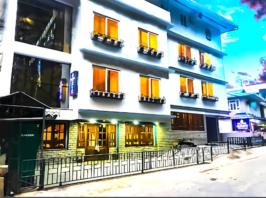 un edificio con ventanas de color naranja y amarillo y una valla en The Loft Norling Hotel & Spa en Bhurtuk