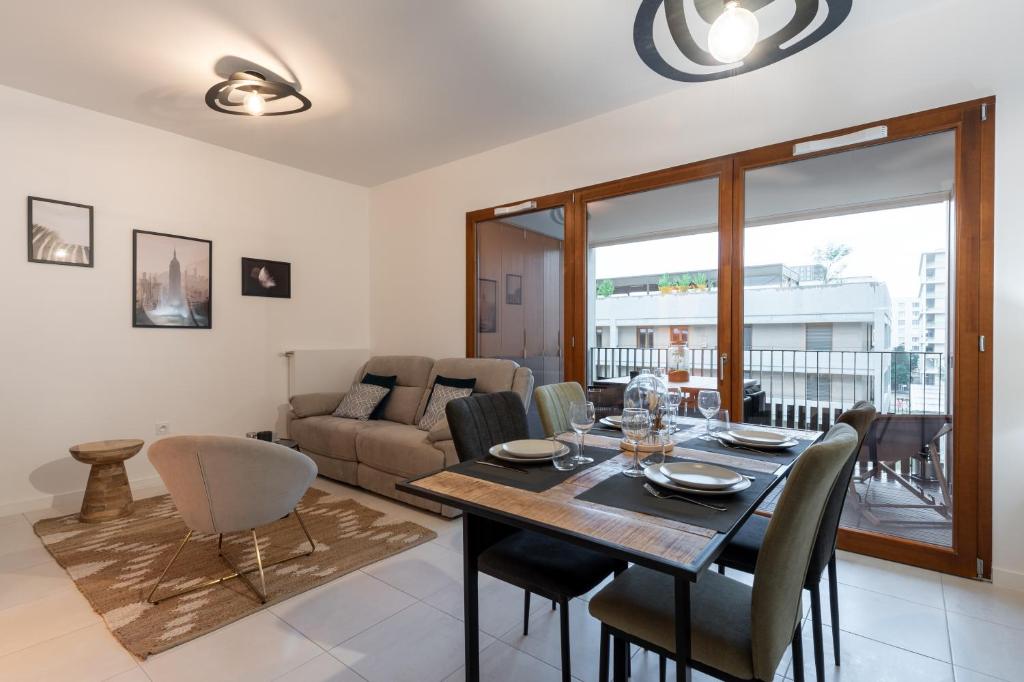 une salle à manger et un salon avec une table et des chaises dans l'établissement Le Conflu Home - En plein cœur de la Confluence, à Lyon