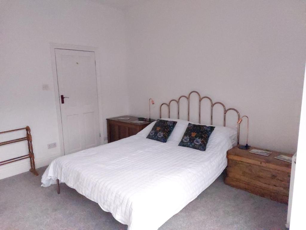 a bedroom with a white bed and a wooden dresser at LetAway - Yonge's Place Saltburn in Saltburn-by-the-Sea