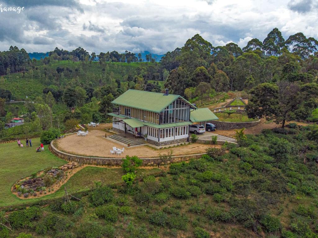 an aerial view of a building in the middle of a field at The Farmhouse Mahaulpatha in Bandarawela