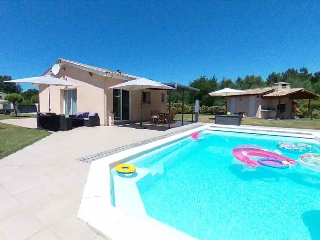 a swimming pool with a frisbee and a house at Mélité in Grayan-et-lʼHôpital