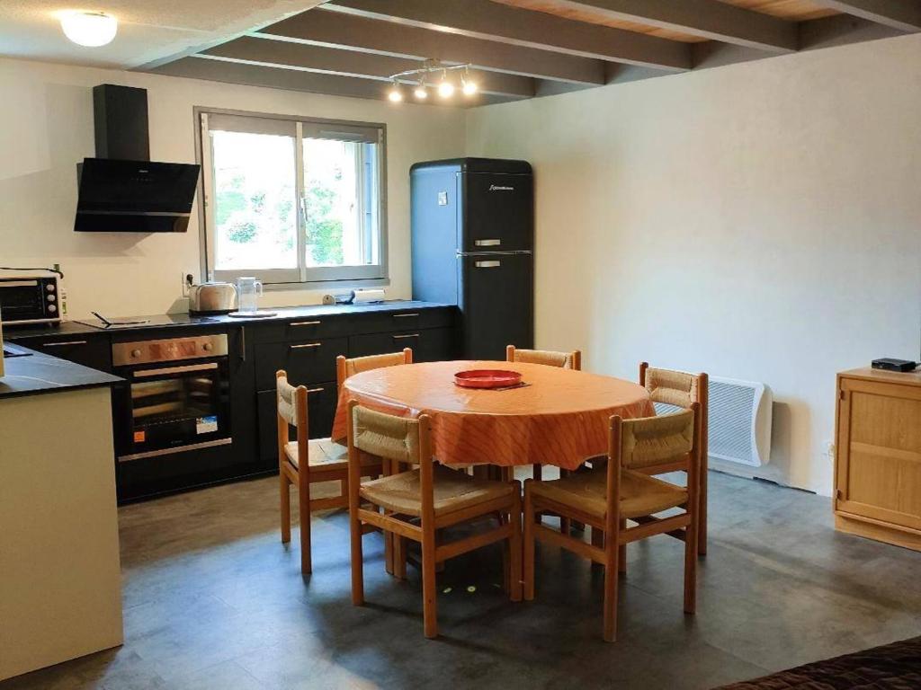 une cuisine avec une table avec des chaises et un réfrigérateur dans l'établissement Appartement Duplex Calme 6 pers, Terrasse, Parking Privé, 500m du Centre - FR-1-234-252, à Cauterets