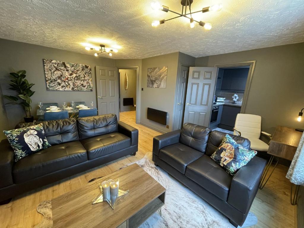 uma sala de estar com dois sofás de couro e uma mesa em No24 - 2-bed Boutique Apartment - Hosted by Hutch Lifestyle em Leamington Spa