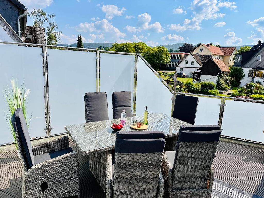 een tafel en stoelen op het balkon van een huis bij FeWo Bachlauf mit großer Terrasse in Bad Harzburg