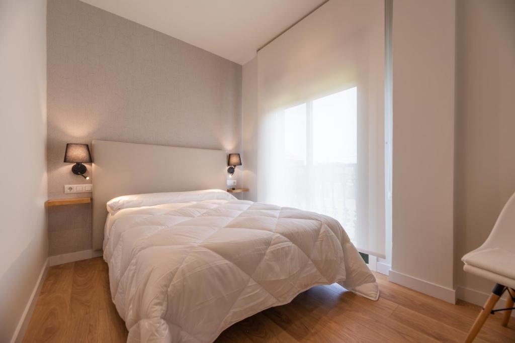 ein Schlafzimmer mit einem weißen Bett und einem Fenster in der Unterkunft Hostal Devesas in O Grove