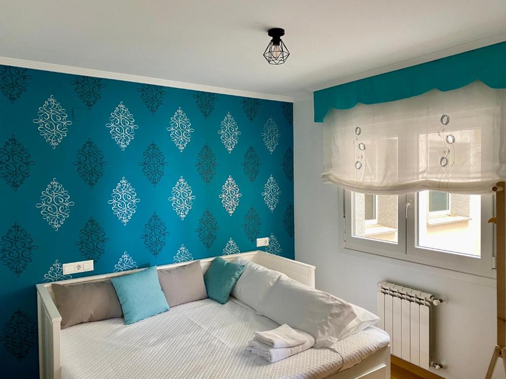sypialnia z łóżkiem z niebieską ścianą w obiekcie Ollo de Llas w mieście Foz