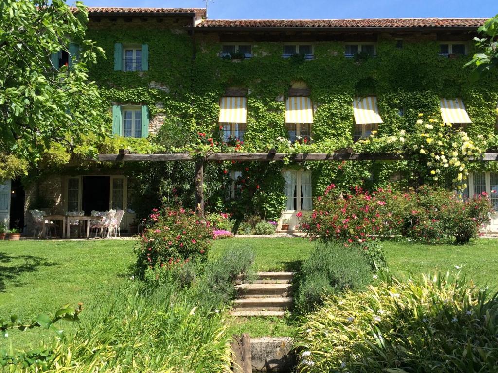 Maso Di Villa Relais Di Campagna في Susegana: مبنى به باقة ورد في الفناء