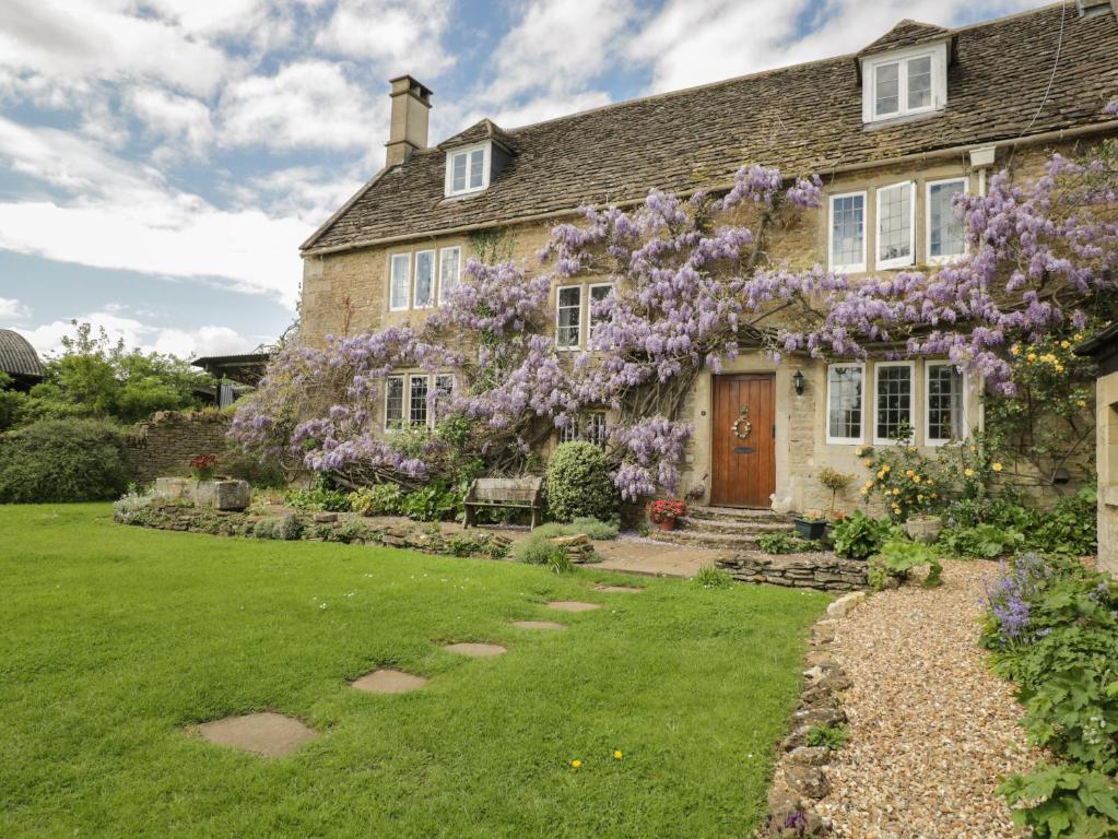 a house with purple flowers on the front of it at Reybridge House in Chippenham